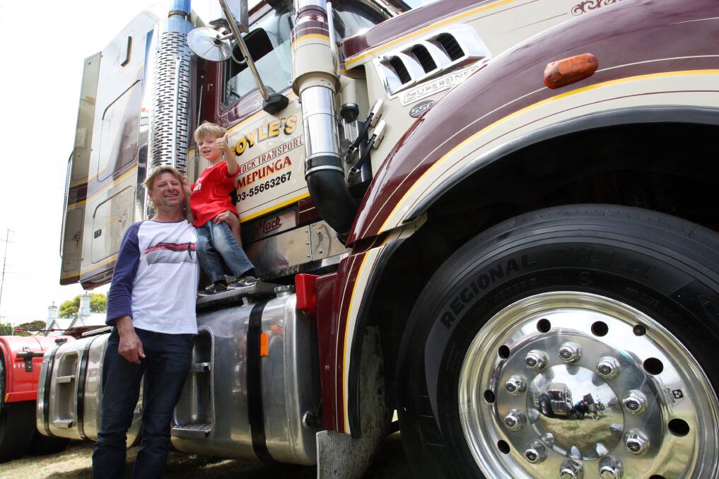 Jamie Haylock and Harry Haylock, 3, from Port Fairy looking at a Mack truck owned by Boyles Livestock in Mepunga.