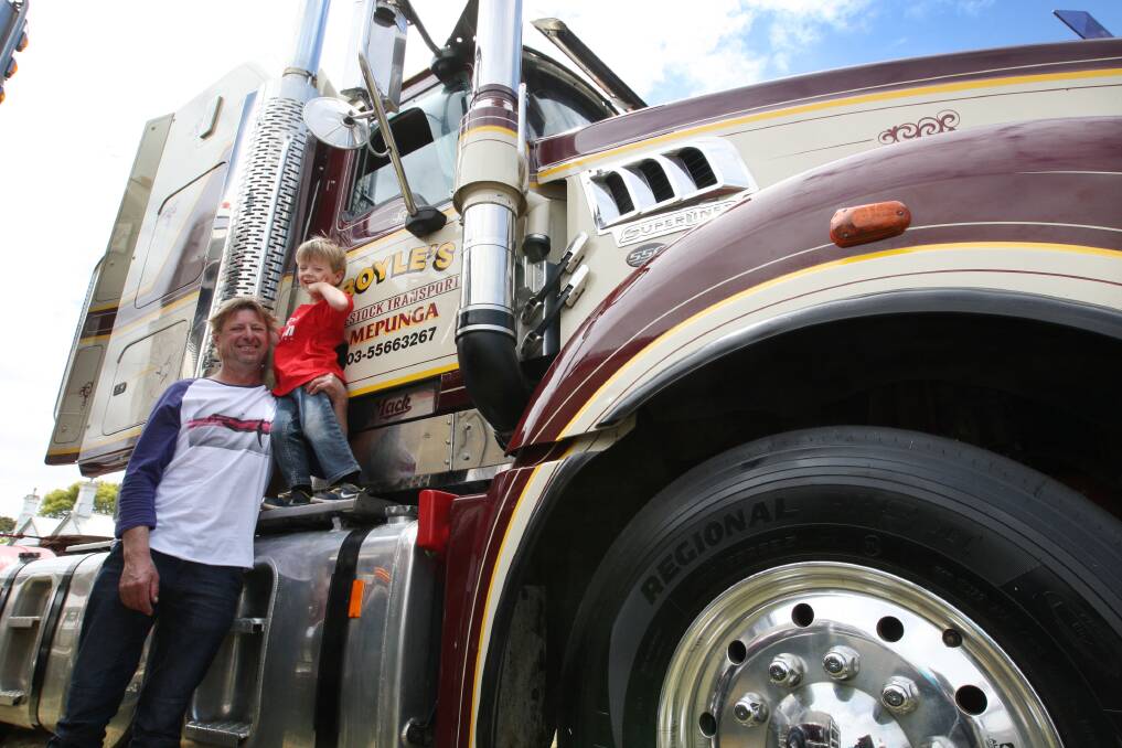 Jamie Haylock and Harry Haylock, 3, from Port Fairy looking at a Mack truck owned by Boyles Livestock in Mepunga. 