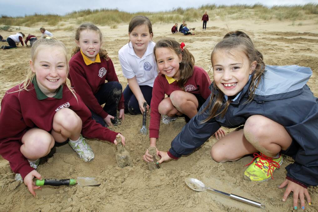 St Pius X Primary School students Ashlyn Kent, 9, Alanna Hansford, 8, Macey Buhlman, 9, Maddie Holley, 9, and Tahlia Walker, 10, with some bottles found in the sand at Illowa/Killarney.