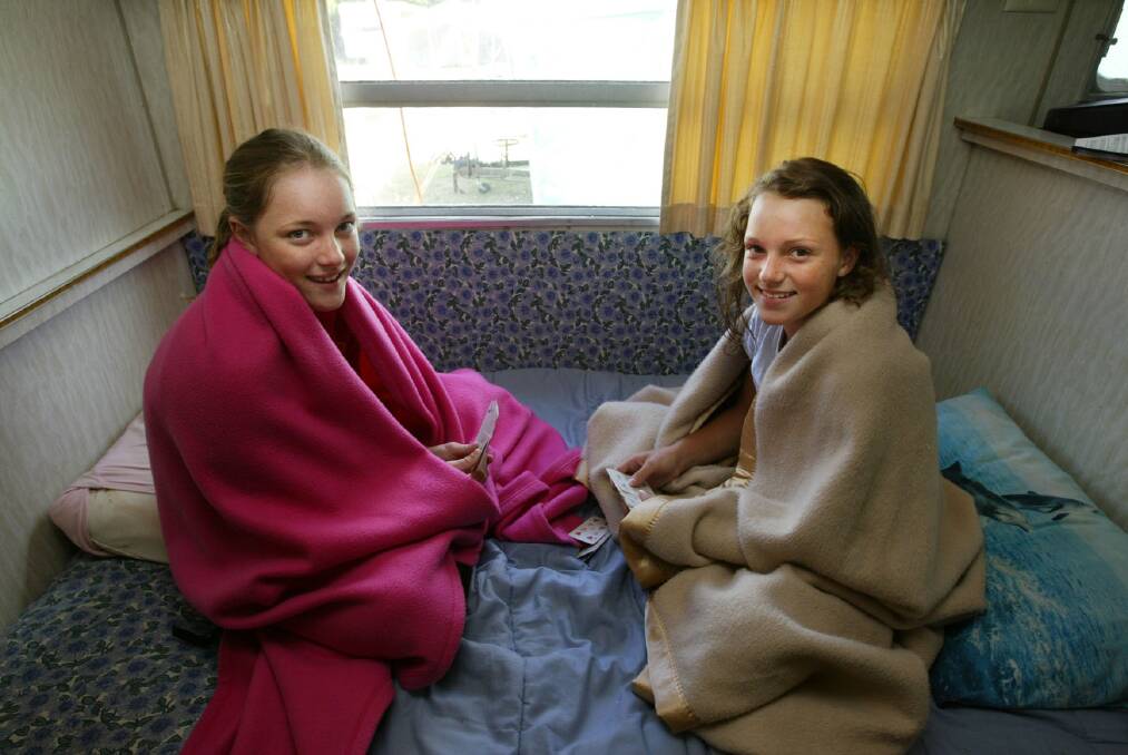 Warrnambool campers Kaitylyn Arnott, 13, and Jessica Irving, 12, playing cards indoors at the Shipwreck Caravan Park due to bad weather.