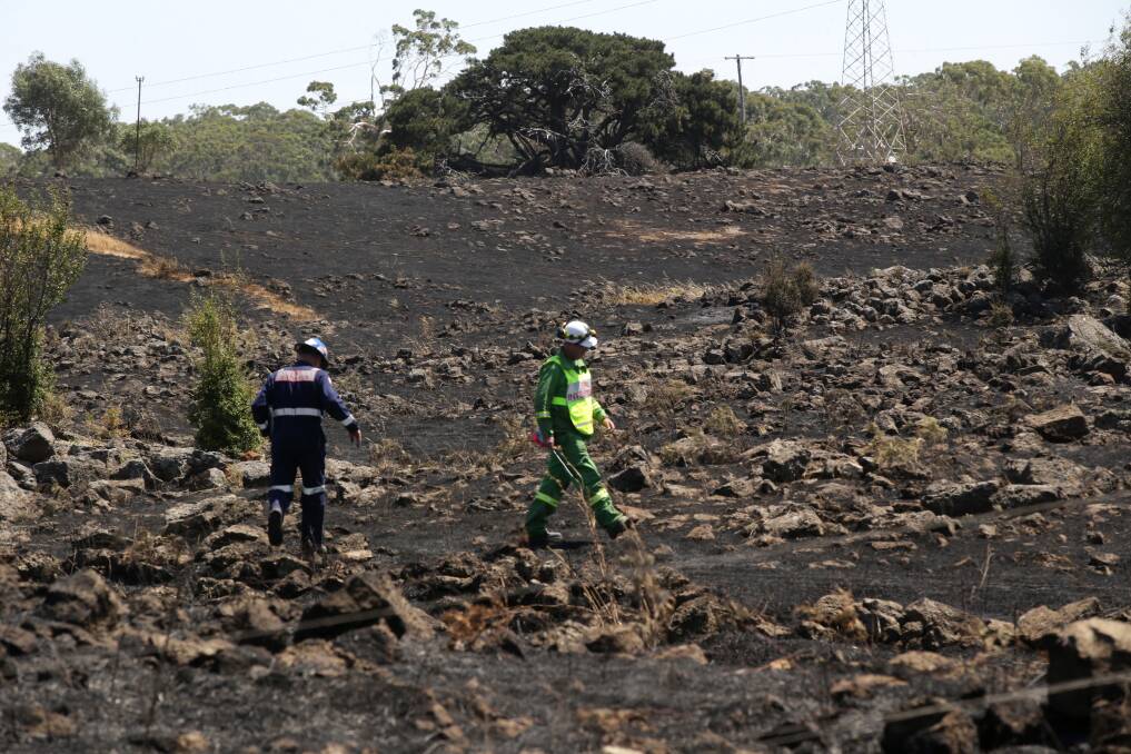 CFA fire investigator Geoff Fisk and his Department of Environment and Primary Industries counterpart Stuart Willsher at work near Stoneyford yesterday.