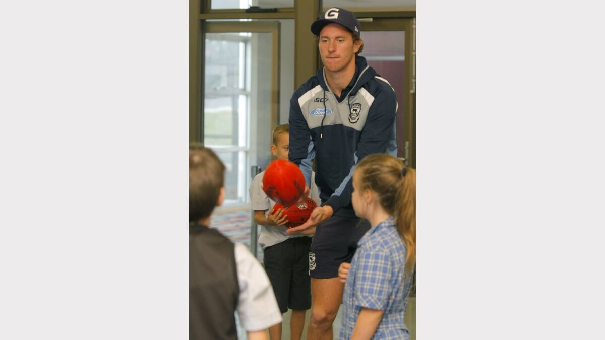 Mitch Brown handballs with King's College grade three students.