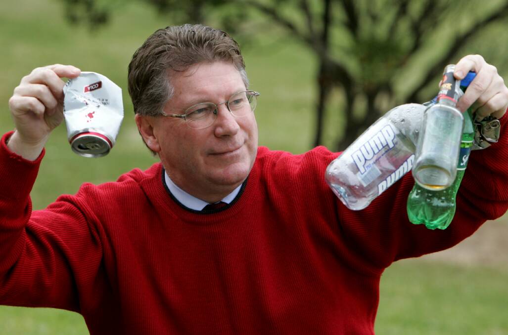 Denis Napthine holding onto bottles and cans that are going into rubbish without being recycled. 