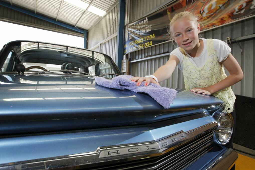 Grace Hasell, 12, polishes her dad's 1964 EH Holden ahead of the Warrnambool drag club's car show.