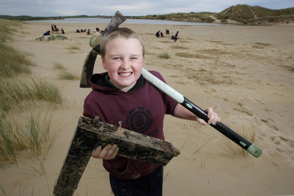 St Pius X Primary School student Zack Lamb, 9, with a piece of timber he dug up on the school's Mahogany Ship search at Illowa.