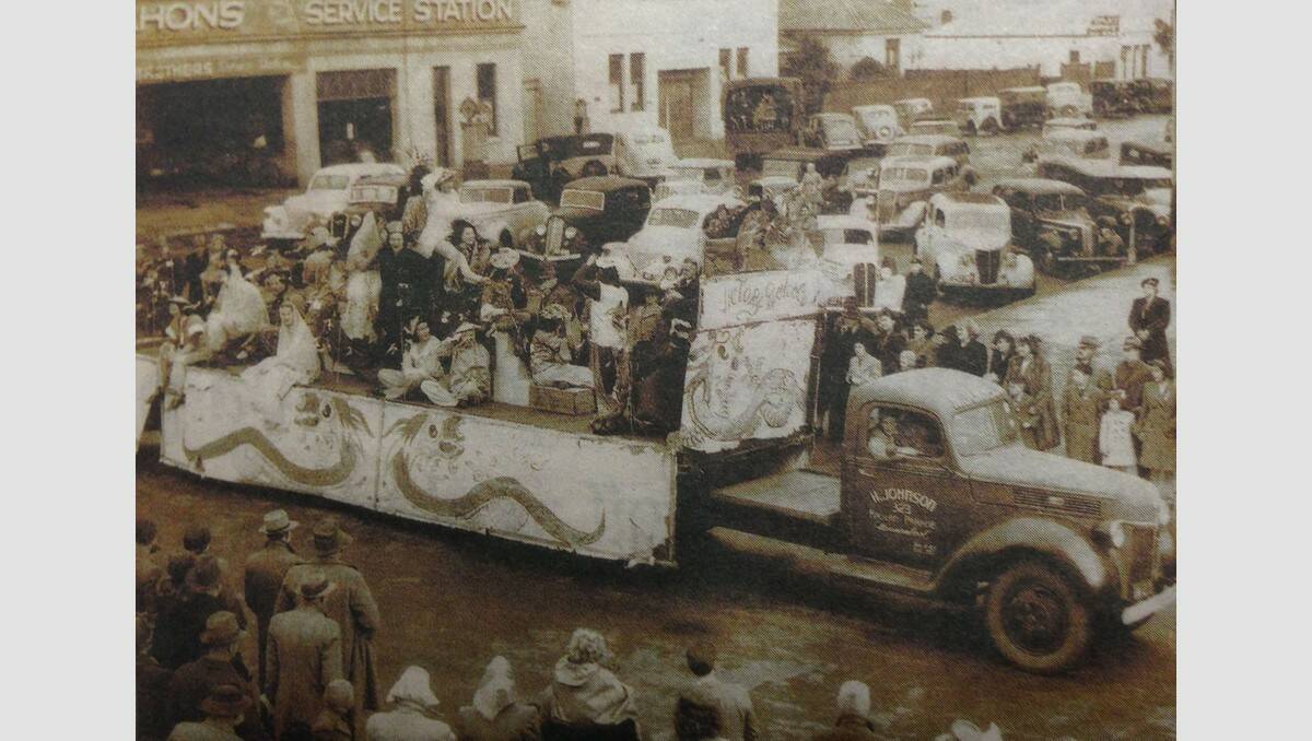 1945 Warrnambool procession celebrating the end of World War II, at intersection of Koroit and Kepler streets. In the foreground is a Ford semi-trailer owned by local transport operator Harry Johnson, carrying characters in costumes. In background is McMahon’s Service station, built in the 1920s and site of a motor business until the 1980s (now Ishka). SOURCE: Warrnambool & District Historical Society.