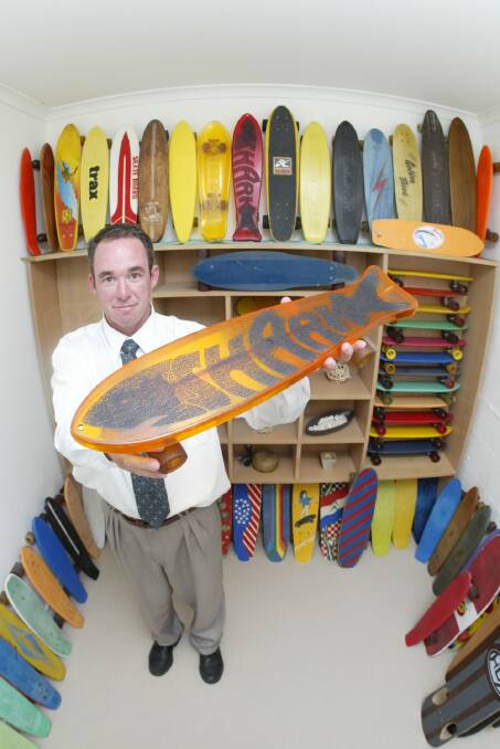 Grant Barker with his well-presented skateboard collection, holding a Lexan 'bullet proof' plastic board from the early 80's called 'Shark'.