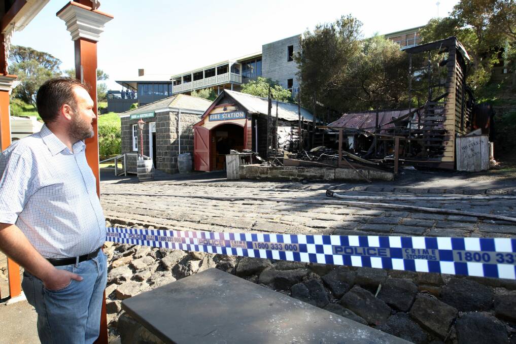 Mr Abbott watches as police and fire officers inspect the damage.