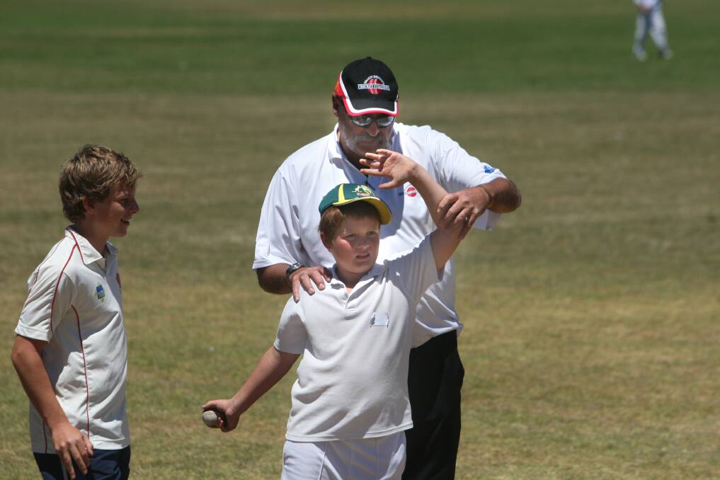 Merv Hughes offers bowling technical assistance to 10-year-old cricketer Jack Trollope.