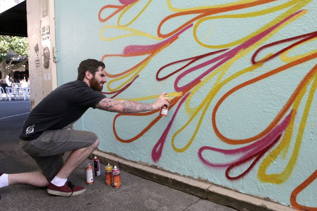 Nathan Pye from Warrnambool paints a laneway wall.