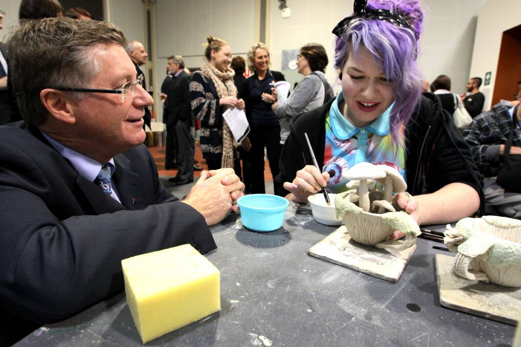 Premier Denis Napthine and tafe art student Bronwen Arnold from Warrnambool working on her ceramic teacups.
