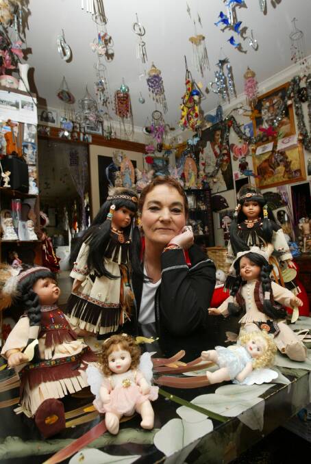 Pam Smith with her collection of wind chimes and dolls.