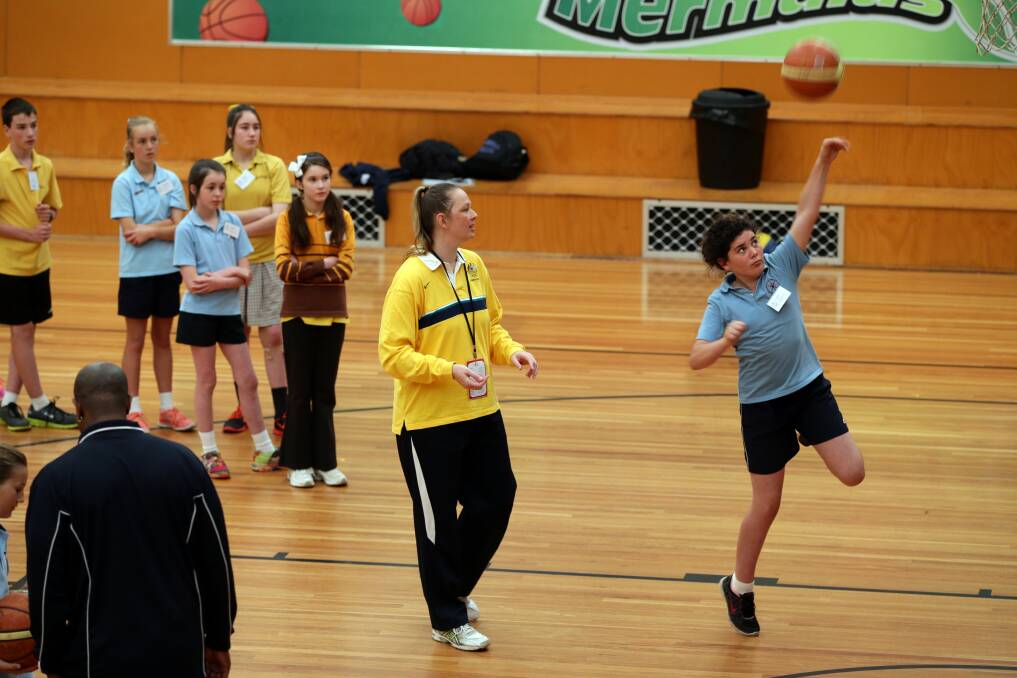 Olympian Michelle Brogan watches Warrnambool East Primary pupil Telicia Brittain's form.