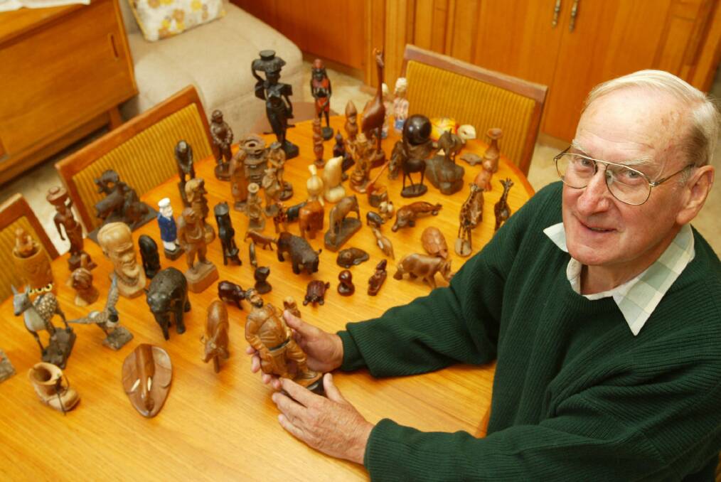 Alan Bowes with wood carvings he has collected on his travels around the world.