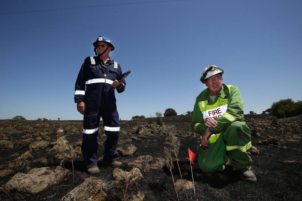 CFA fire investigator Geoff Fisk (left)  and his Department of Environment and Primary Industries counterpart Stuart Willsher at work near Stoneyford yesterday.