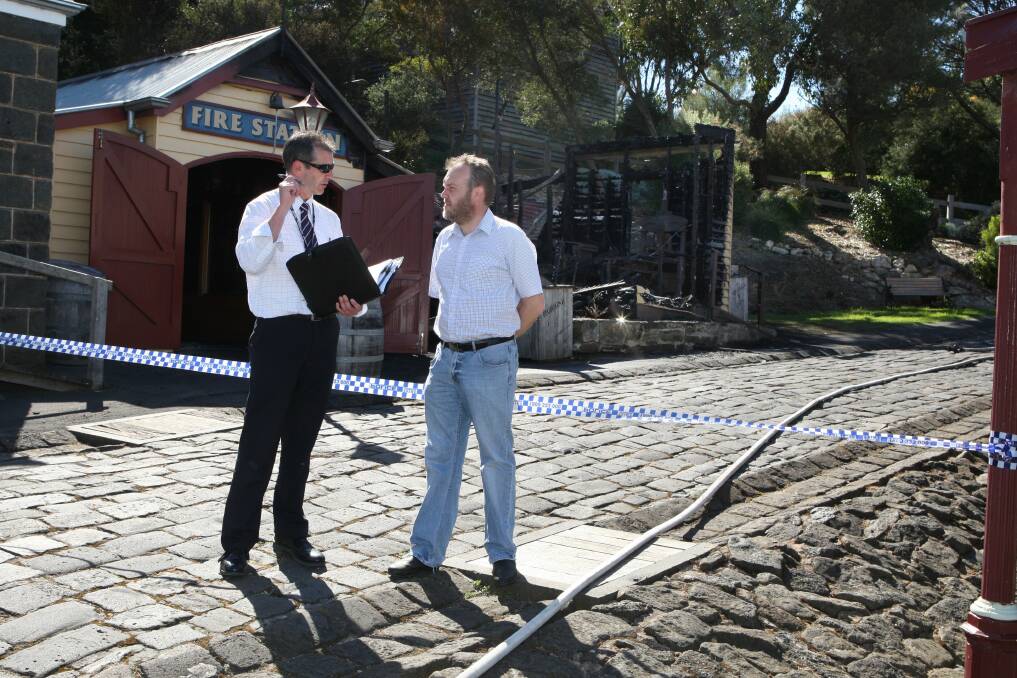 Detective Senior Constable Jason Bourke from Warrnambool CIU talks to Mr Abbott as they look at the damage.