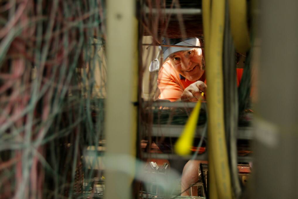 Telstra technician Alan McInnes, Woodend, works to connect the last of the home phone's that have been cut since the fire at the Warrnambool Exchange. 