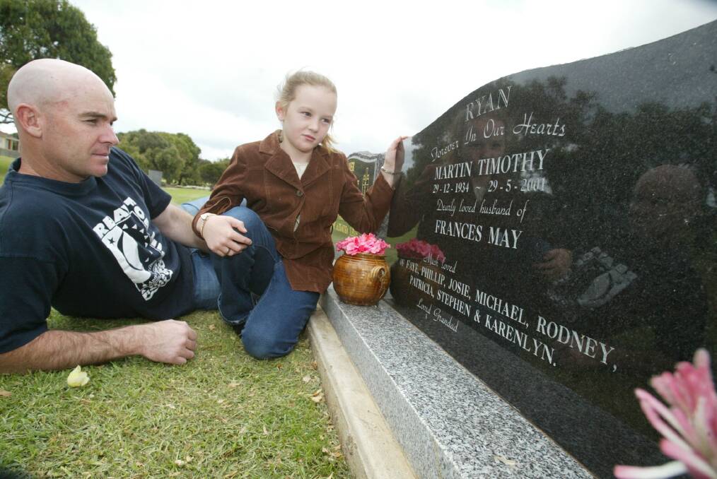 Relay for Life South West district co-ordinator Rodney Ryan with his niece Emily Porra, 8, looking at his father's grave at the Warnambool Cemetery.