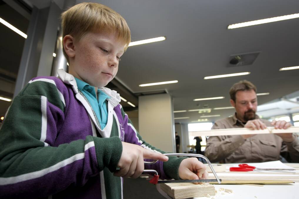 Thomas Digney, 8, from All Saints Primary School Portland, joins his dad Justin Digney, the Great South Coast Science and Engineering Challenge chair, in building a balsa wood bridge.