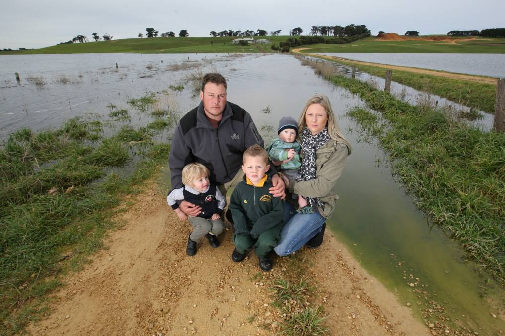 The Holloway family are unable to access their house through their driveway. Ben is pictured holding Mitchell, 2, Riley, 5, and Melissa with 10-month-old Dusty Holloway. Picture: VICKY HUGHSON