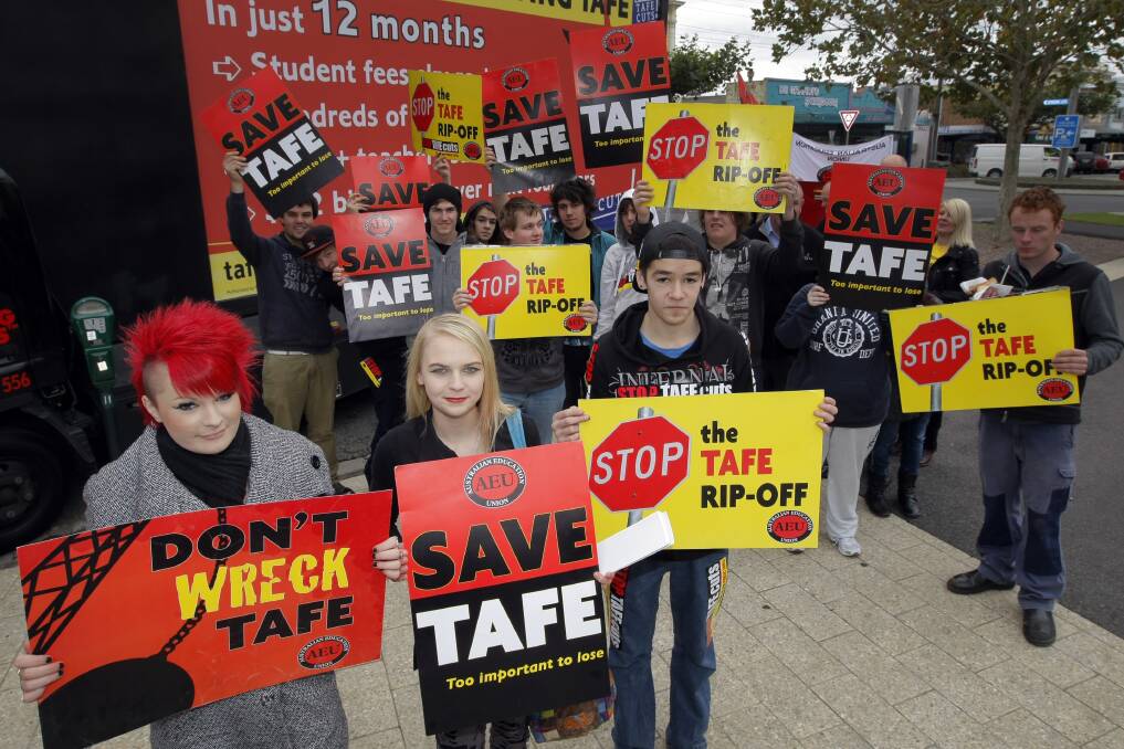 Hairdressing student Shiame Furness, hair and beauty student Madelyn Fogarty-Commelly, and VCAL student Tobias Barker, 16, front a group of TAFE students protesting funding cuts to the TAFE sector.