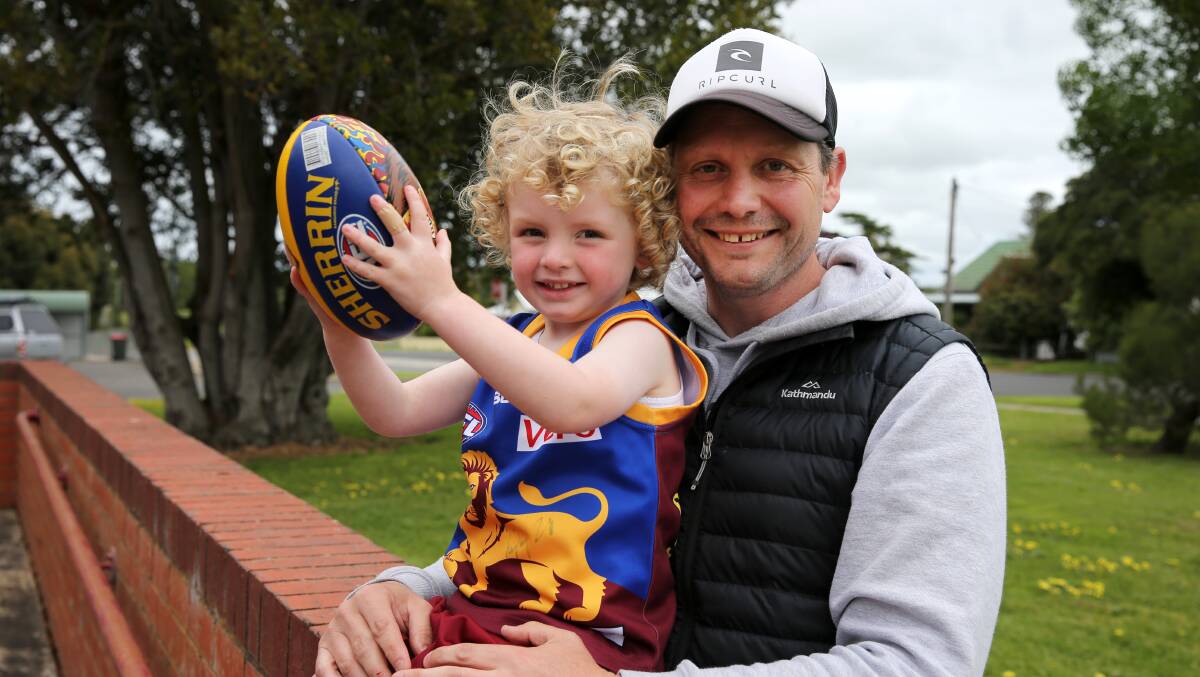 Paul Henriksen with son Jonty after signing as a Brisbane development coach in 2016.