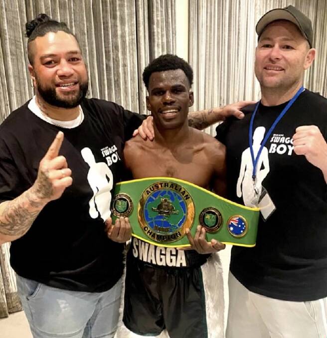 Brian Agina celebrates his Australian boxing title alongside coach Chris Folima (left) and manager Ricky Leonard (right). Picture supplied