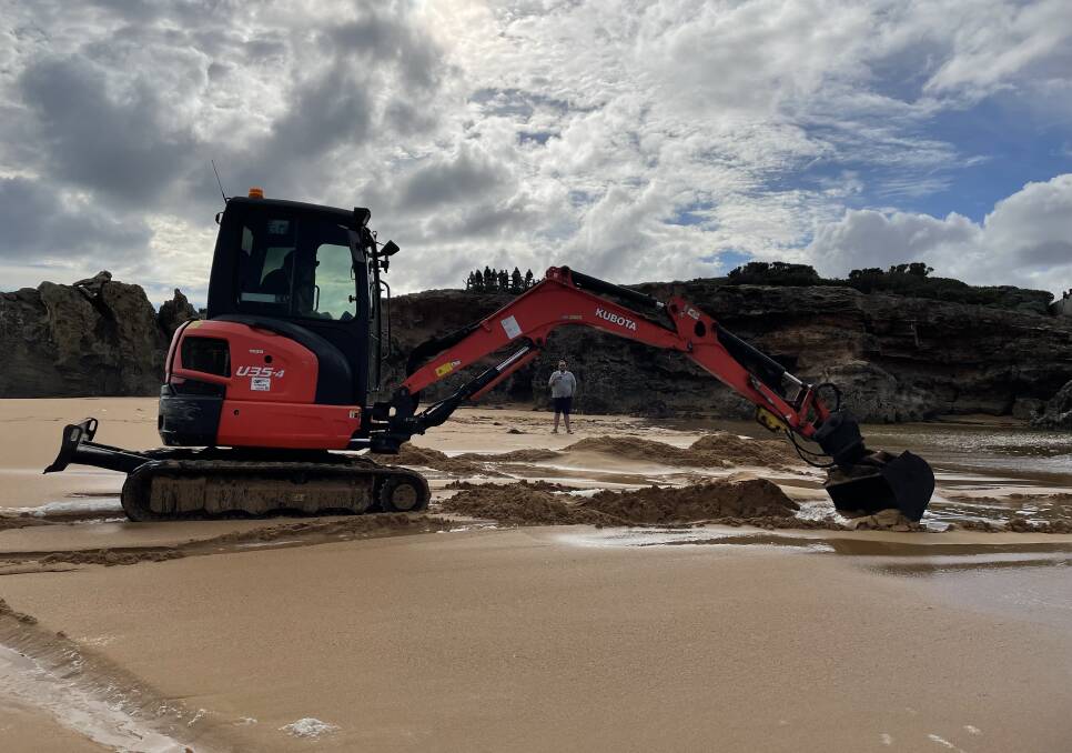 Digging for freedom: A council worker came down in an excavator to dig a channel and help the eels make a break for it. Picture: Ben Silvester.
