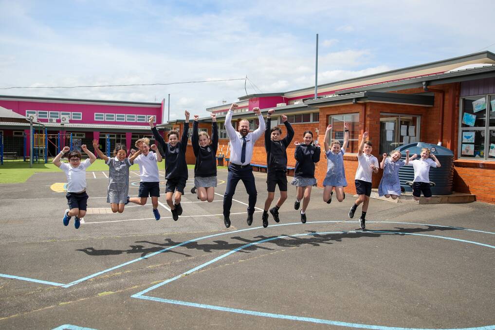 Jumping for joy: St Pius X principal Joe Ewing, centre, says a $1 million federal grant will finally allow the school to bring its middle years area up to modern standards. Picture: Morgan Hancock.