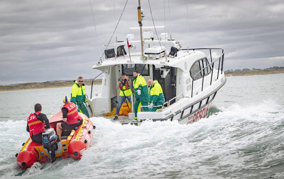 The Port Fairy surf lifesavers are pulled in towards the marine rescue service boat. Pictures by Sean Mckenna