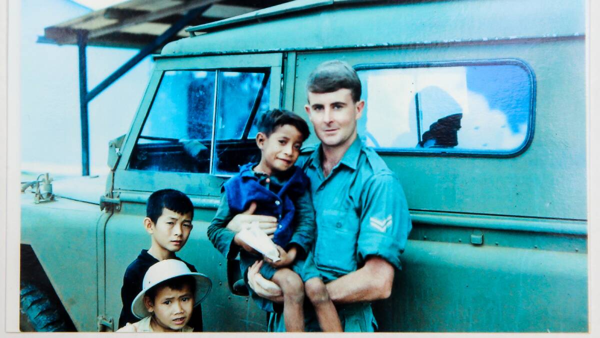 Corporal Ken Cummings, Warrnambool, holding the boy called Rabbit, while on station in Vietnam.