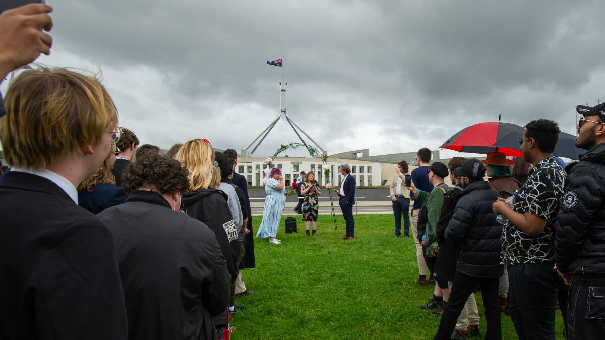 National Union of Students members, Ebony Martinesz and Max Marlans, get fake married by union president Georgie Beatty on the lawns of Parliament House. Picture by Elesa Kurtz