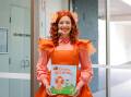 Emma Watkins as her character Emma Memma holding a copy of her book at the Warrnambool Library and Early Learning Centre on Friday, September 15. Picture by Anthony Brady