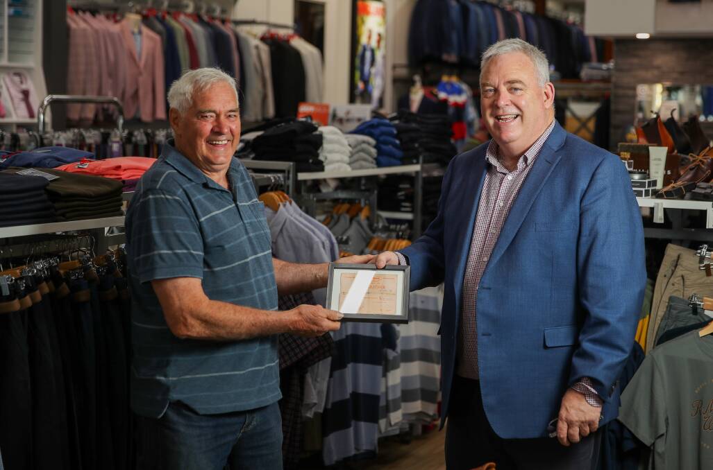 RETAIL: Warrnambool man Phillip Hicks and Clancey's Menswear owner and manager Peter Clancey with a 45-year-old gift voucher Mr Hicks presented for use. "I don't know why I kept it for so long," Mr Hicks said. Picture: Morgan Hancock