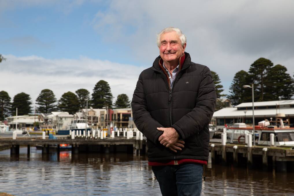 Moyne mayor Ian Smith stands in front of the Moyne River with The Wharf at Port Fairy in the background.