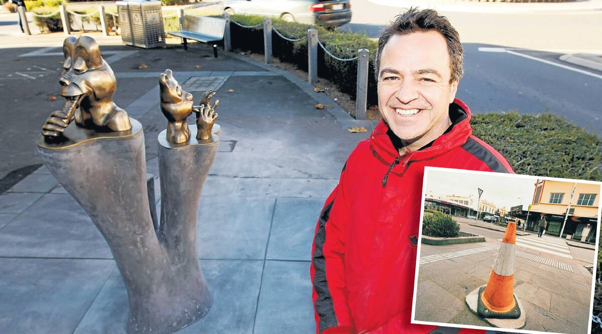 Ewen Coates with his Warrnambool sculpture Three Pillars of Instant Gratification in 2010. The sculpture was removed more than six months ago for its Koroit Street site and a cone covers the base.