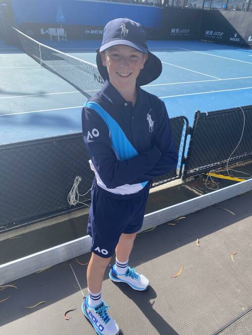 Luke Robson stands in front of a tennis court in his 2024 Australian Open ballkid uniform at Melbourne Park.