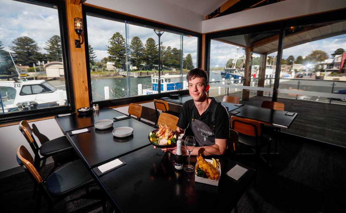 The Wharf at Port Fairy restaurant owner Sean Malady sits at a table with food. 