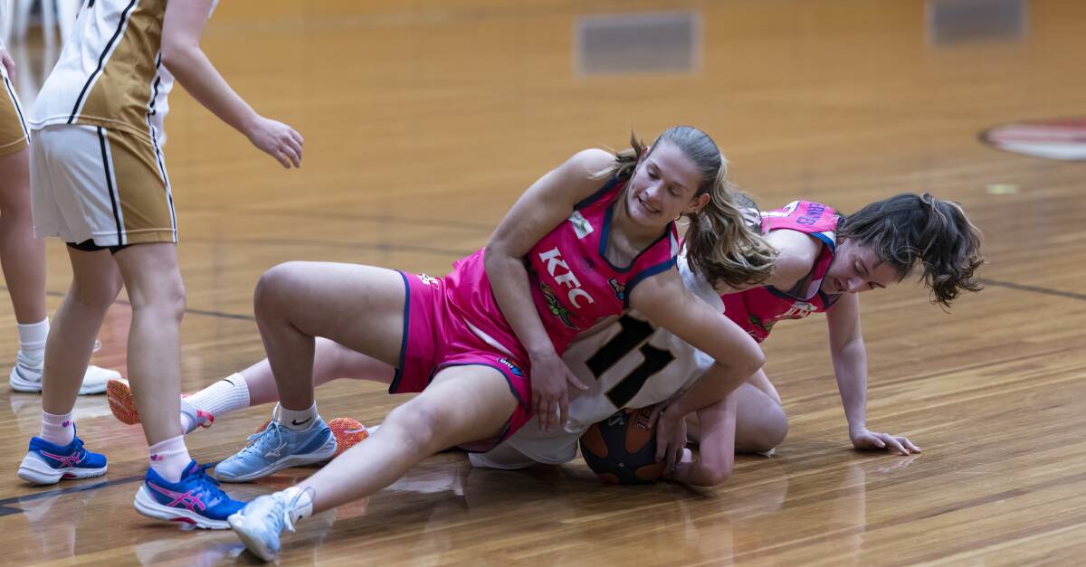Warrnambool duo Elise Thurman and Amy Wormald battle a Warrandyte opponent for possession of the ball on Saturday night. Picture by Larry Lawson