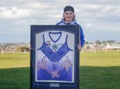 HONOURED: Kobi Chatfield, 13, with a framed Russells Creek's Indigenous guernsey he designed. Picture: Anthony Brady
