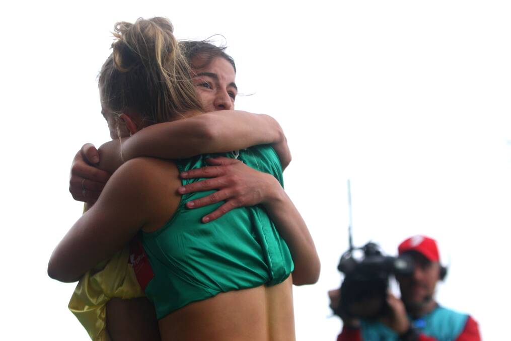 Layla Watson (in green) hugs Stawell Gift winner Bella Pasquali moments after they crossed the finish line. Picture by Meg Saultry