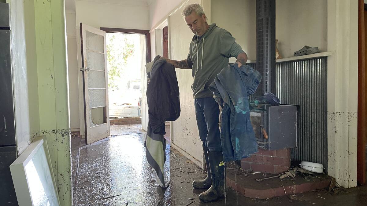 John Harriot sifts through what's left of his belongings after flash-flooding ripped through his Cootamundra home. All pictures by Conor Burke