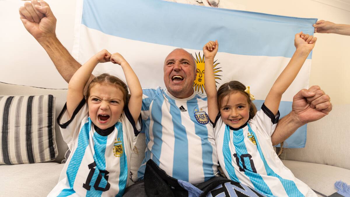 Bailey Zeunert, left, Isla Zeunert, right, and their grandfather Sandro Schietroma, middle, will be cheering for Argentina bright and early on Monday morning. Picture by Sean McKenna