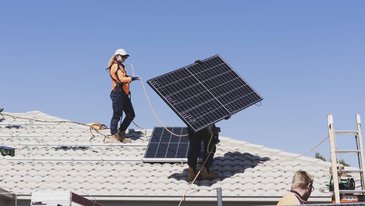 Workers installing solar panels on a house in Bonner, ACT. Picture: Dion Georgopoulos.