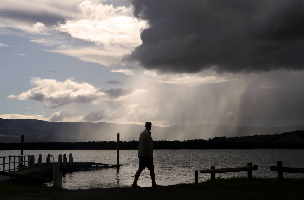 Dramatic rain clouds dominate the sky off Lake Illawarra. Picture by Sylvia Liber. 