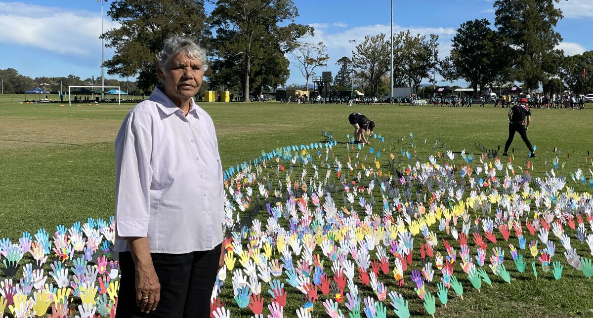 Eileen Button in front of the Sea of Hands created by Macleay Valley students. Picture by Ellie Chamberlain