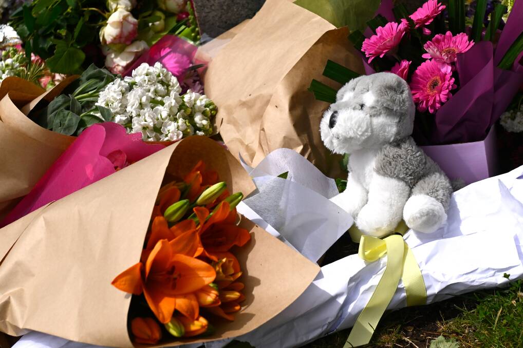 Toys for the sick and dead children - aged from 11 months to six years - have been placed among the hundreds of flowers at a statue on the corner of Albert and Vincent streets. Picture by Adam Trafford.