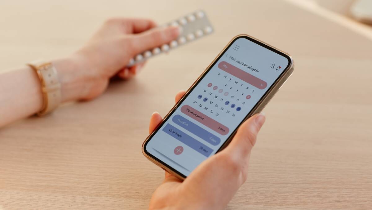 Woman calculating menstrual cycle using mobile app. Picture by Shutterstock.