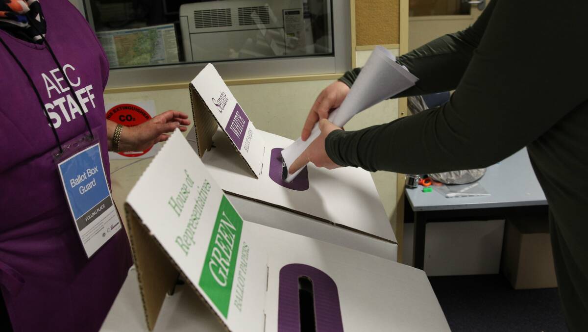 A voter submits their ballot papers at the ballot box. Picture by Max Mason-Hubers.