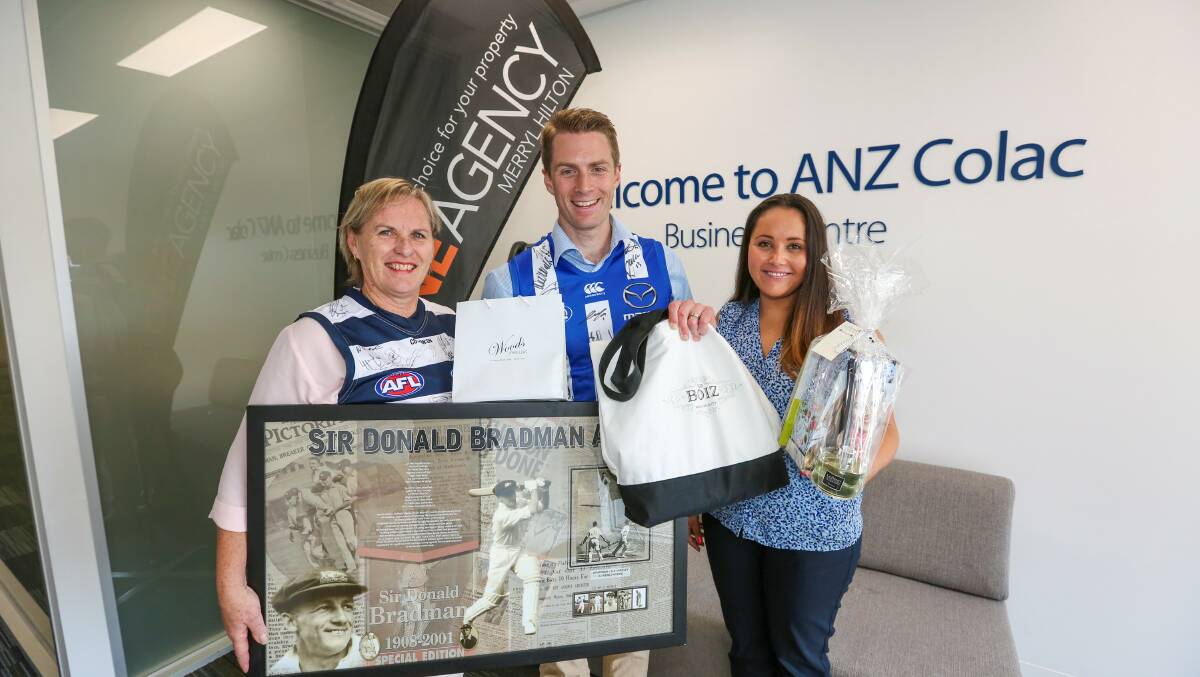 With some of the $30,000 of items to be auctioned on Saturday in support of victims of the St Patrick's Day fires are One Agency Colac's Merryl Hilton and ANZ's Dale Camm and Alana Pittard. Picture:  Tammy Brown